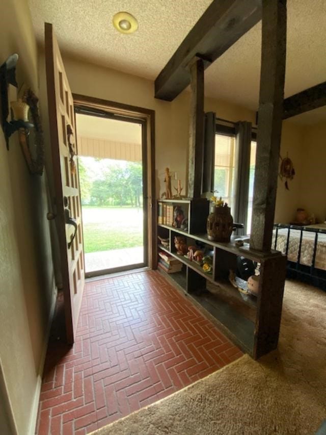 doorway to outside featuring a textured ceiling