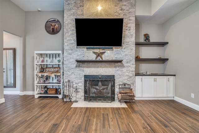 unfurnished living room featuring built in features, a fireplace, and dark wood-type flooring