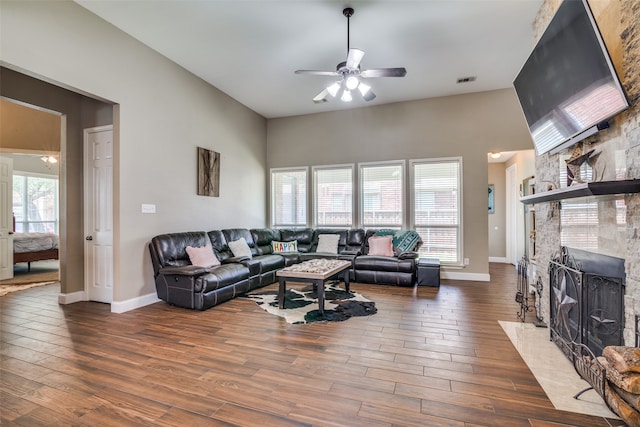 living room featuring dark hardwood / wood-style flooring, a fireplace, and ceiling fan