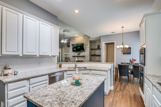 kitchen with a kitchen island, stainless steel appliances, pendant lighting, wood-type flooring, and sink