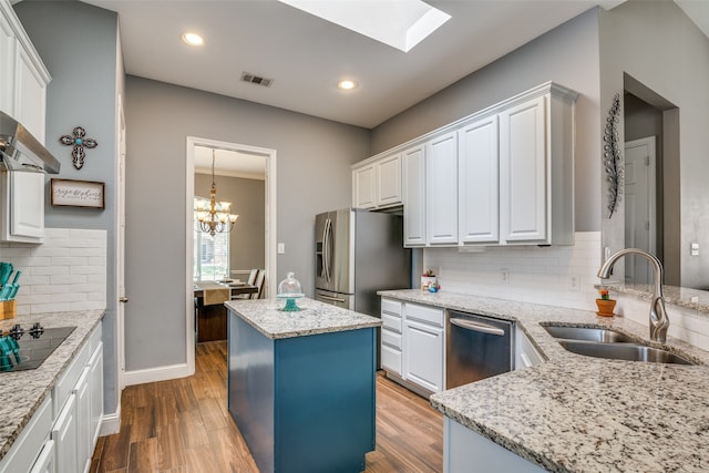 kitchen featuring a kitchen island, sink, hardwood / wood-style flooring, and backsplash