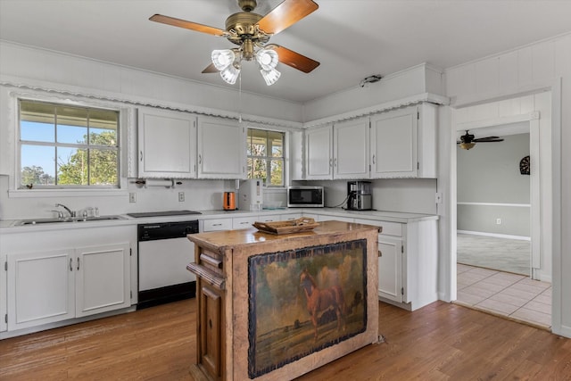 kitchen featuring white cabinets, dishwasher, sink, ceiling fan, and light hardwood / wood-style flooring