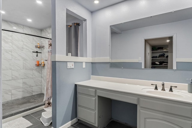 bathroom featuring tile patterned flooring, walk in shower, and vanity