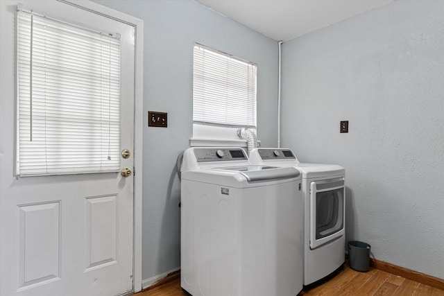 laundry room with light wood-type flooring and washer and clothes dryer