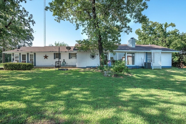 rear view of house featuring a lawn