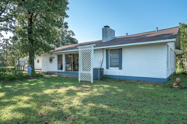 rear view of property featuring a lawn