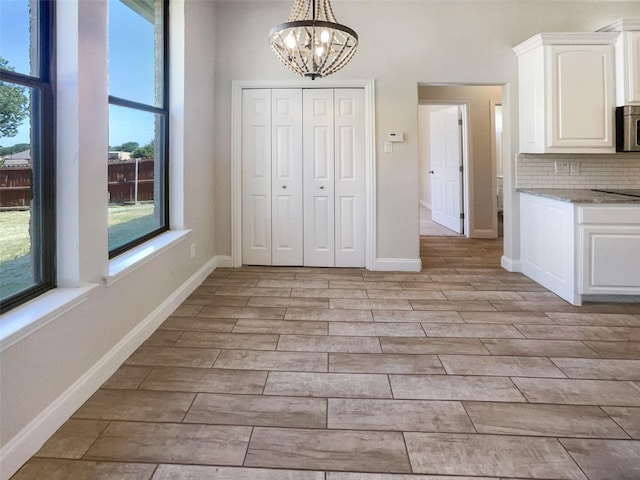 unfurnished dining area with light hardwood / wood-style flooring and a chandelier