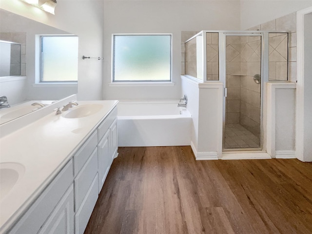 bathroom featuring hardwood / wood-style flooring, a wealth of natural light, vanity, and separate shower and tub