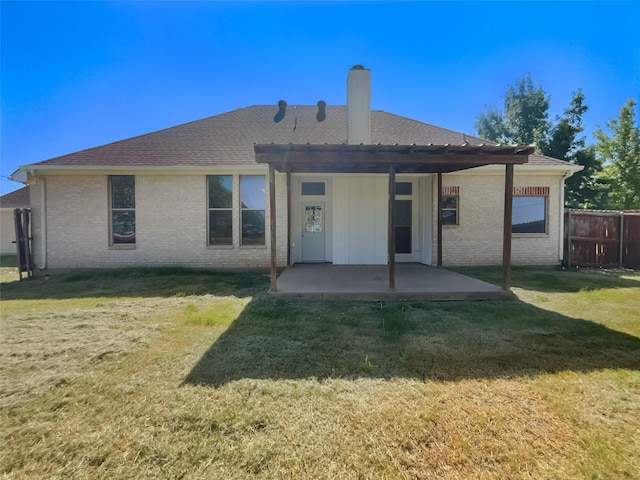 back of property with a patio, a pergola, and a lawn