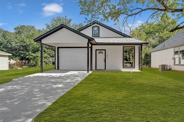 view of front of home featuring central AC, a garage, and a front lawn