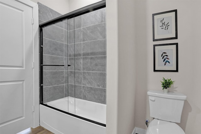 bathroom featuring toilet, combined bath / shower with glass door, and hardwood / wood-style flooring