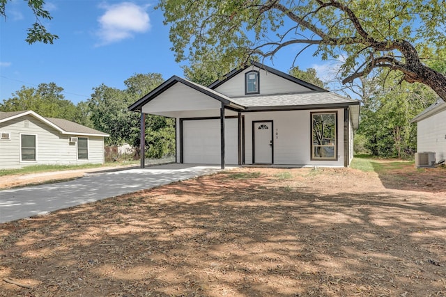 view of front of property with a garage and cooling unit