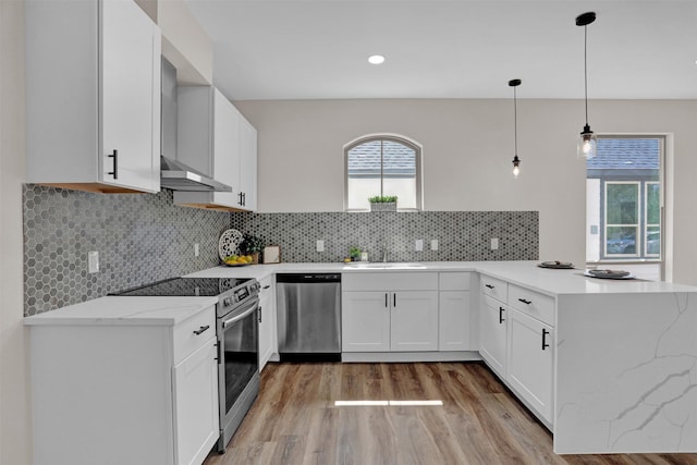 kitchen featuring kitchen peninsula, sink, hanging light fixtures, stainless steel appliances, and white cabinets