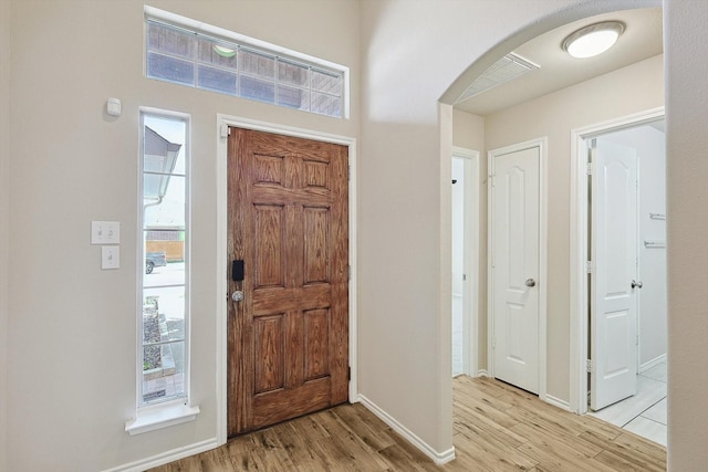 10517 Wentworth Dr, Rowlett, TX 75089 - entrance foyer with arched walkways, light wood-type flooring, and baseboards