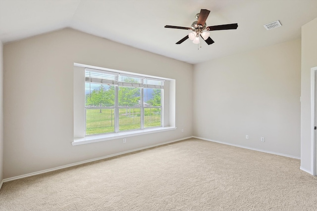 carpeted spare room featuring ceiling fan and vaulted ceiling