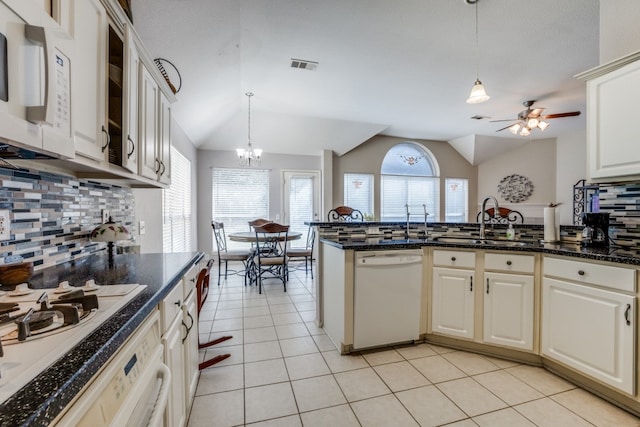 kitchen featuring tasteful backsplash, white appliances, sink, vaulted ceiling, and light tile patterned floors