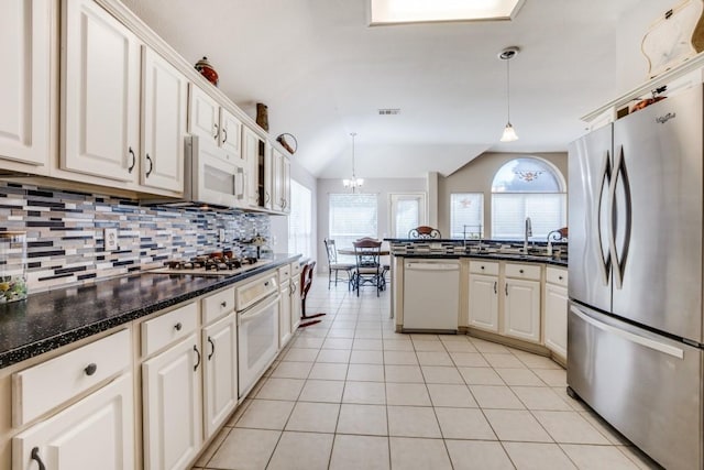 1514 Murphy Dr, Rockwall, TX 75087 - kitchen with tasteful backsplash, lofted ceiling, light tile patterned floors, white appliances, and decorative light fixtures