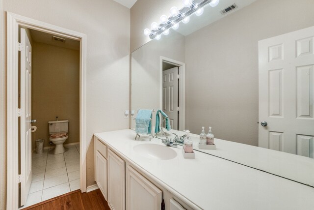 bathroom with vanity, wood-type flooring, and toilet