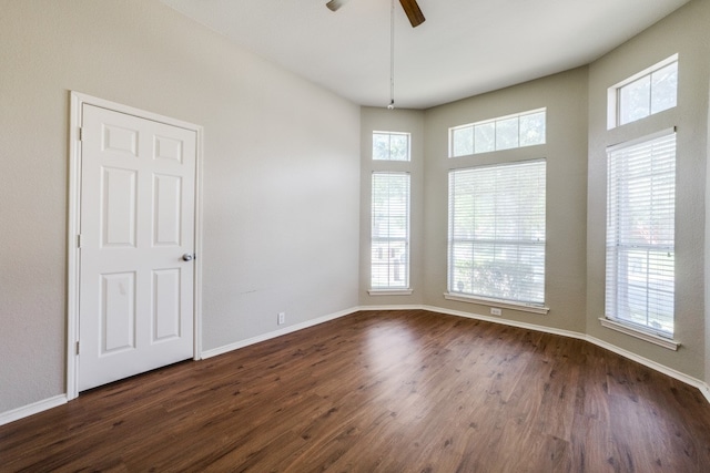 spare room featuring plenty of natural light, dark wood-type flooring, and ceiling fan