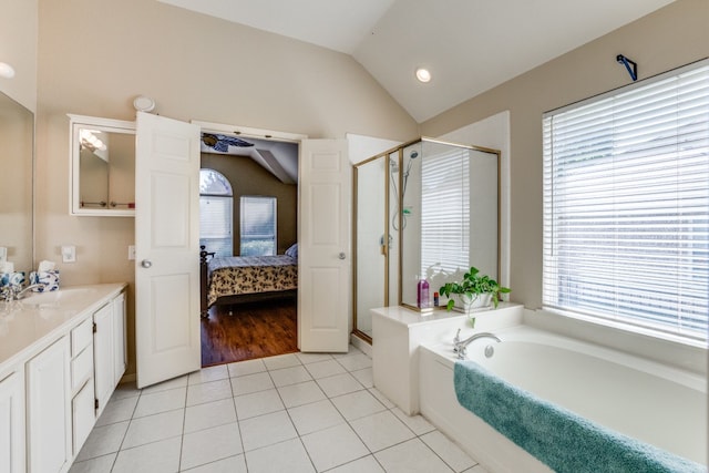 bathroom with vaulted ceiling, vanity, plus walk in shower, and tile patterned floors