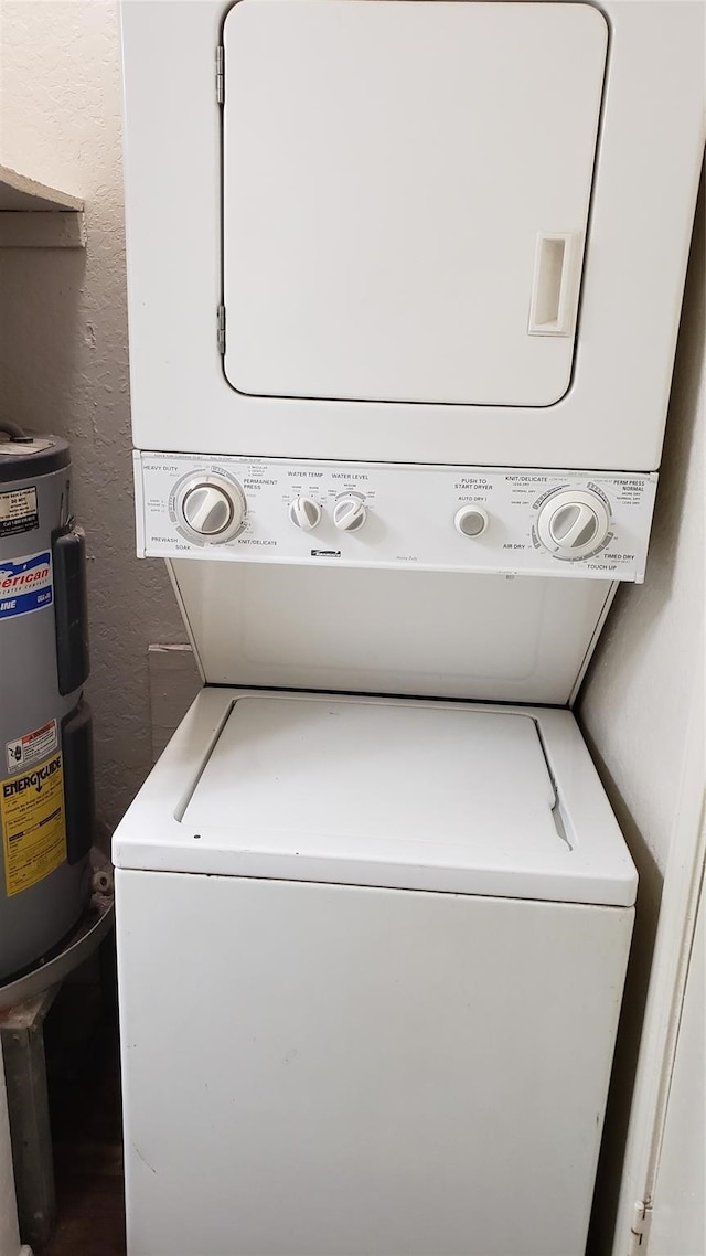 washroom featuring stacked washer / dryer and water heater