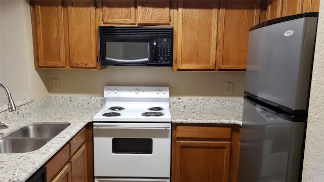 kitchen featuring sink, black appliances, and light stone countertops