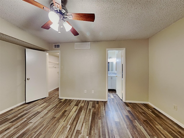 unfurnished bedroom featuring a closet, ceiling fan, ensuite bath, hardwood / wood-style floors, and a textured ceiling