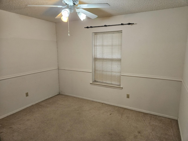 unfurnished room featuring a textured ceiling, light colored carpet, and ceiling fan