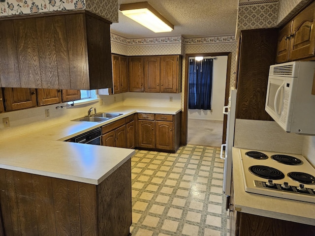 kitchen with kitchen peninsula, dark brown cabinets, white appliances, a textured ceiling, and sink