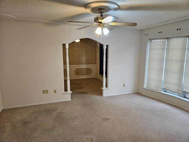 carpeted empty room with ceiling fan and a textured ceiling