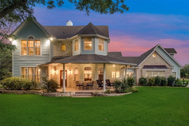 view of front of home with a front lawn, covered porch, and a garage