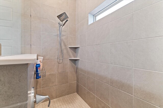 bathroom with vanity, tile patterned flooring, and tiled shower