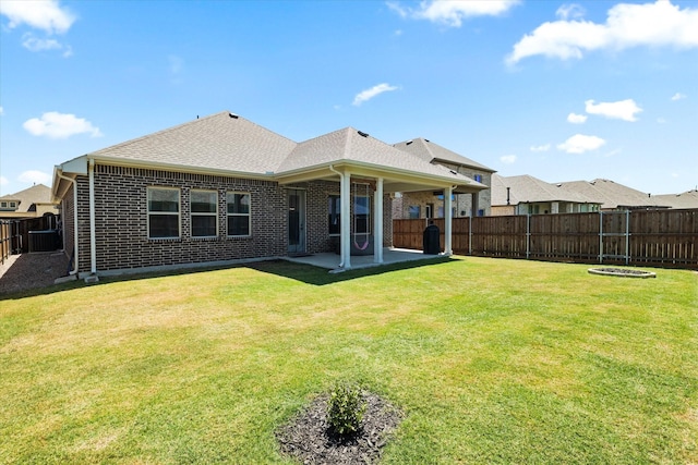 rear view of house featuring a yard and a patio