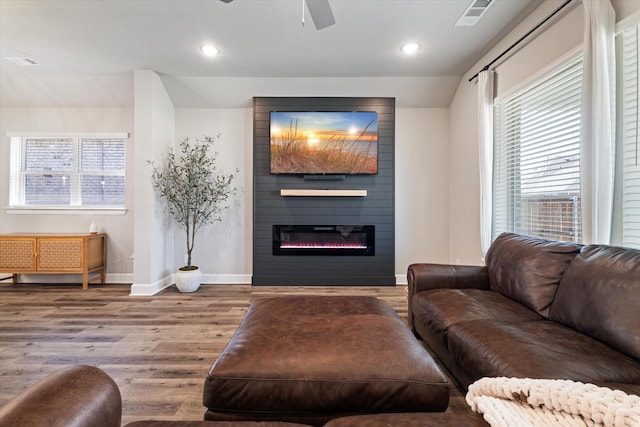 living room with ceiling fan, a fireplace, and light hardwood / wood-style flooring