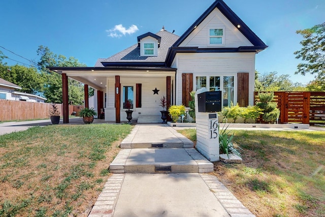 view of front of home with a porch and a front yard