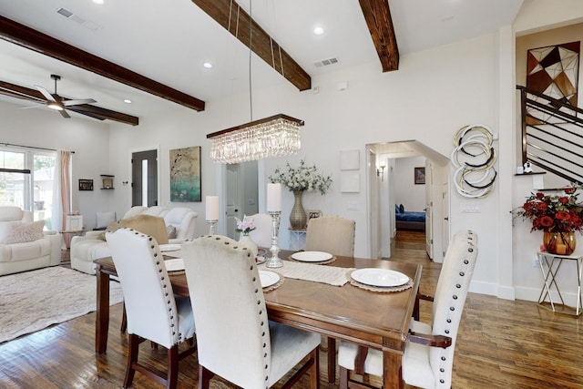 dining room with beam ceiling, ceiling fan with notable chandelier, and dark hardwood / wood-style floors