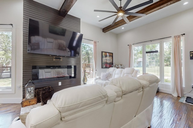 living room with beamed ceiling, a large fireplace, light hardwood / wood-style flooring, and plenty of natural light