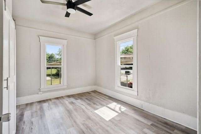 spare room with plenty of natural light, ceiling fan, and light wood-type flooring