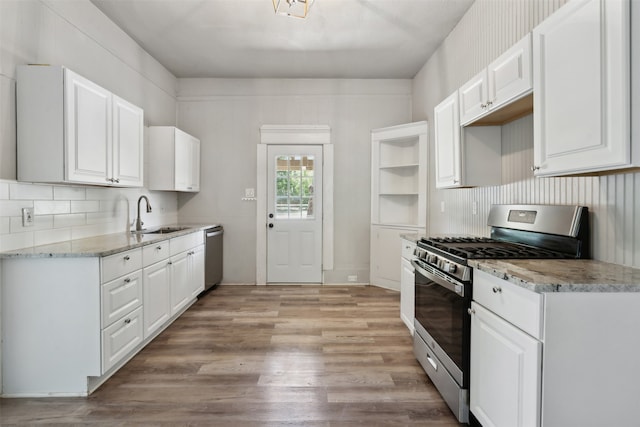 kitchen with white cabinets, light hardwood / wood-style flooring, appliances with stainless steel finishes, and sink