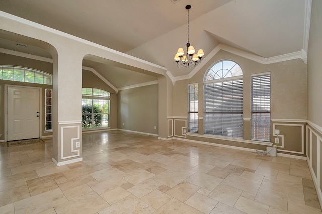 spare room with plenty of natural light, vaulted ceiling, crown molding, and a chandelier