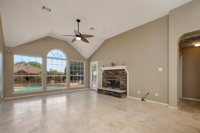 unfurnished living room with vaulted ceiling, a stone fireplace, and ceiling fan