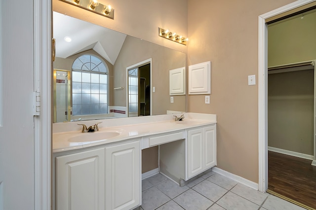 bathroom with tile patterned flooring, vanity, and vaulted ceiling