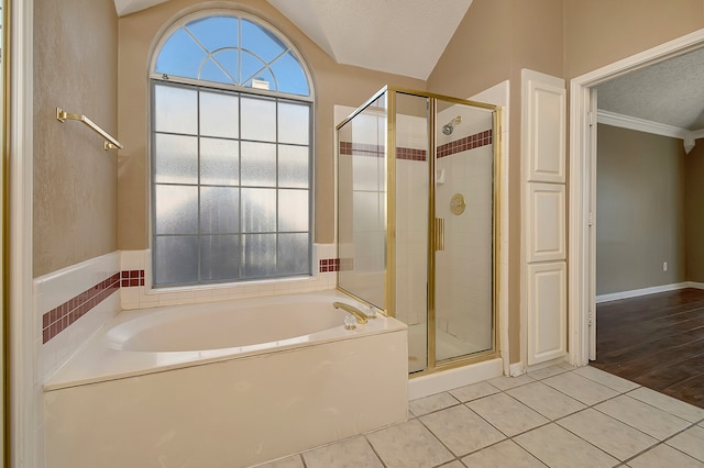 bathroom with tile patterned flooring, vaulted ceiling, and independent shower and bath