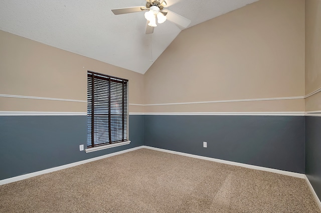 carpeted empty room featuring ceiling fan and lofted ceiling