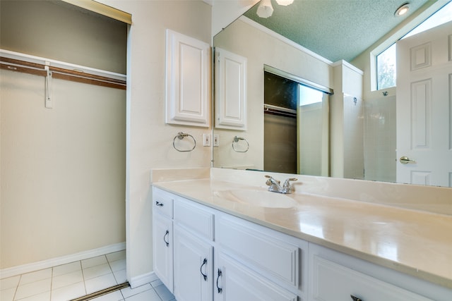 bathroom featuring a textured ceiling, vaulted ceiling, walk in shower, tile patterned floors, and vanity