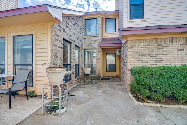 property entrance with a patio and a wall unit AC