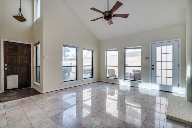 entrance foyer with high vaulted ceiling, a textured ceiling, and light tile patterned flooring