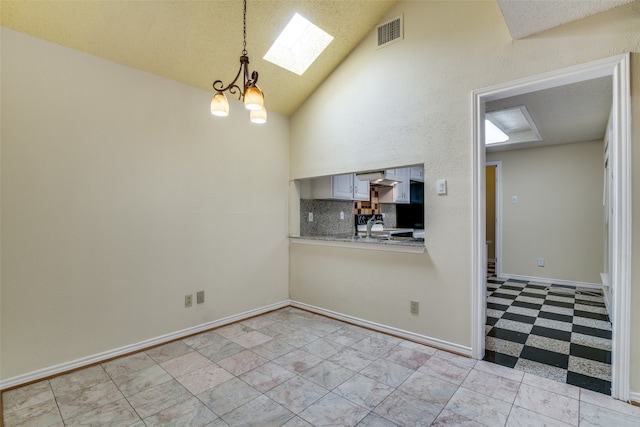 kitchen featuring hanging light fixtures, decorative backsplash, high vaulted ceiling, exhaust hood, and a skylight