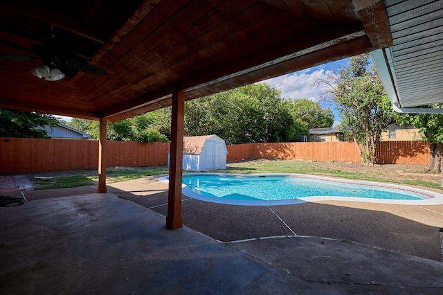 view of pool with ceiling fan, a patio, and a storage shed