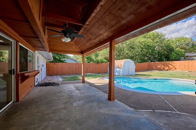 view of pool featuring a patio, a shed, ceiling fan, and a lawn